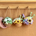 Three crocheted hanging flower pots with different arrangements